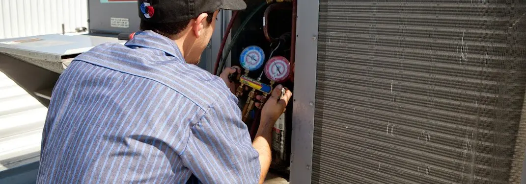 HVAC technician servicing a condenser unit in Lake Forest Park